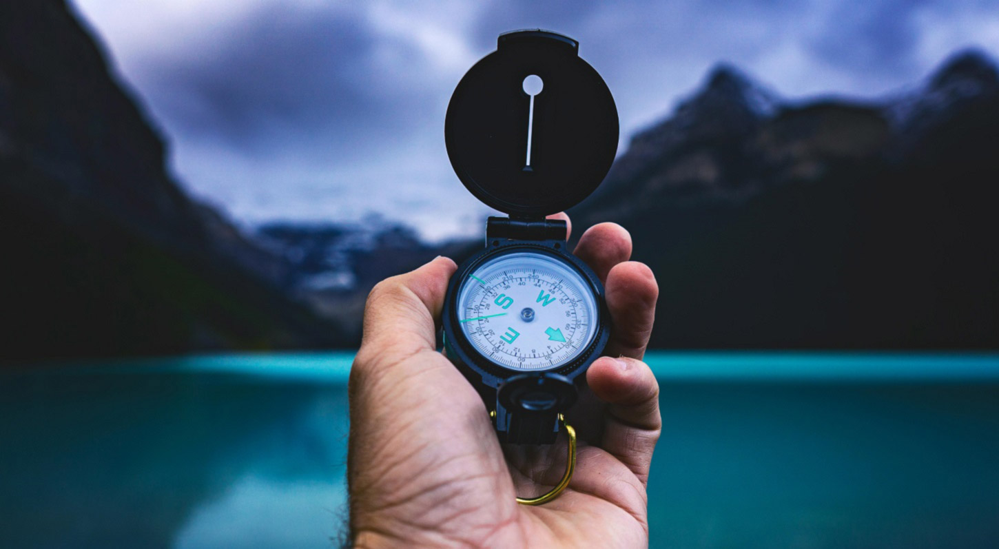 A person holding a compass is like a PPC specialist looking for a ad strategy for their clients