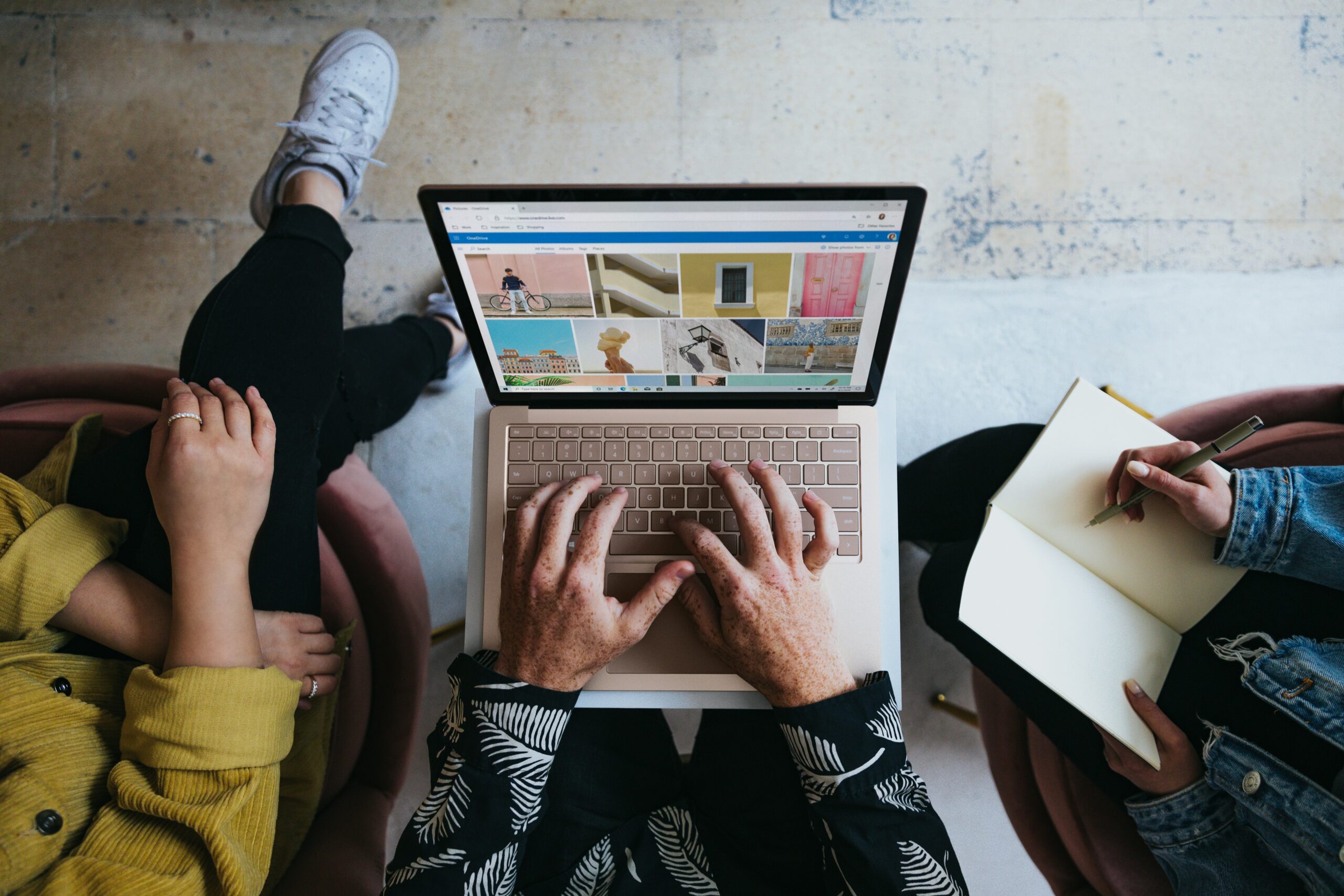 three marketers around a laptop looking for stock images