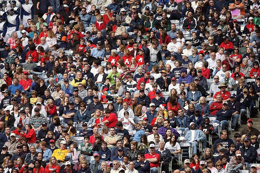 A crowd of sports fans watch from the stands.