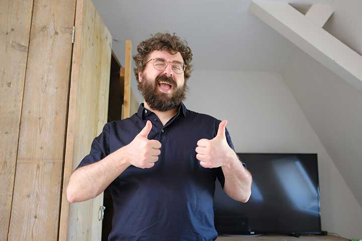 A man smiles, winks, and gives two thumbs up as positive feedback for your content piece.