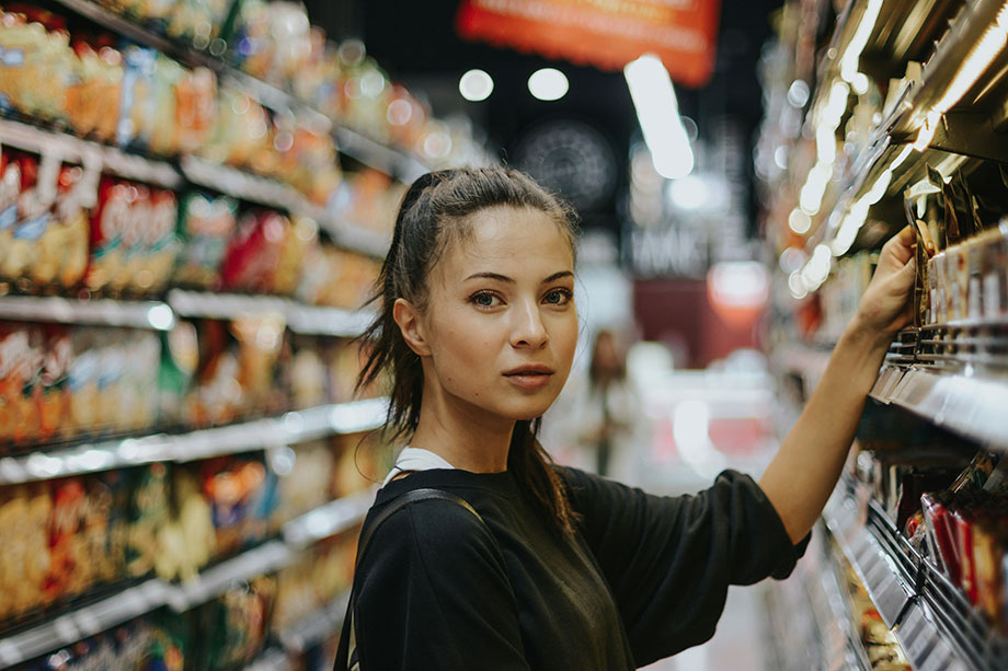 a woman in a supermarket shops for specific brands she likes