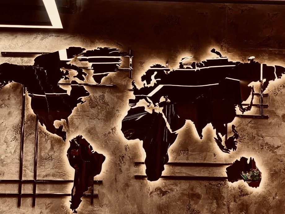 a concrete wall with a map of the continents on it, lit from behind