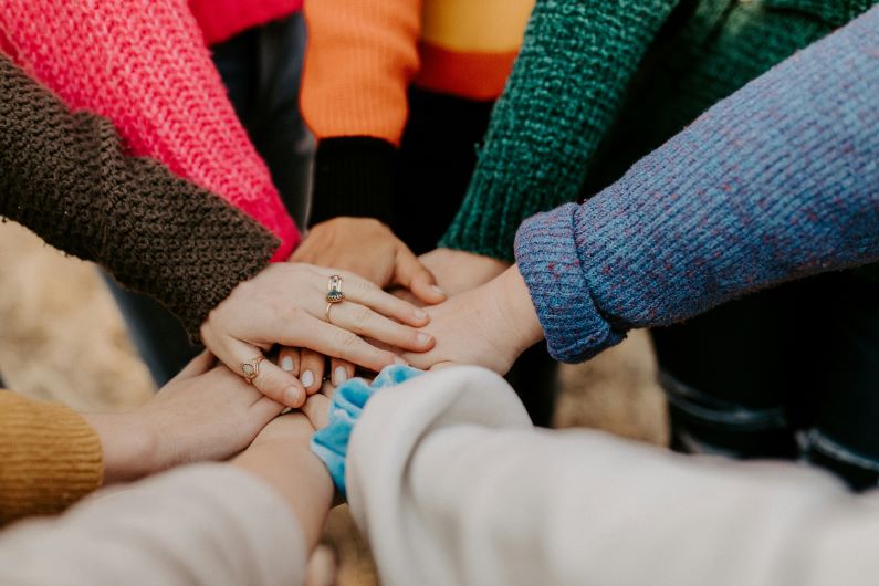 close up of women's hands all together in a circle