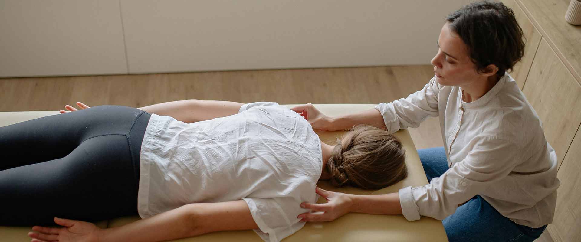 Chiropractic professional performing a spinal adjustment on a patient.